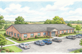 Exterior of a single-story rural community hospital with a small parking lot.